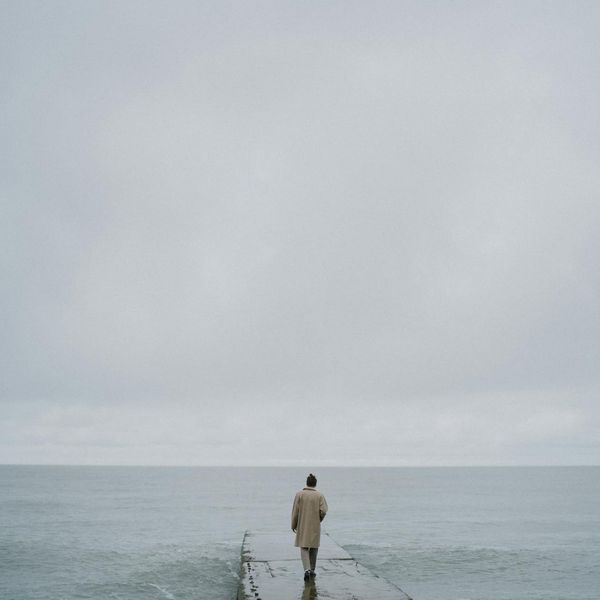 A person meditating peacefully in a calm, minimalist environment.